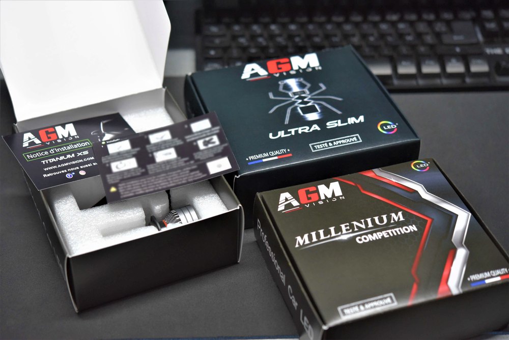 Förpackningar med AGM Vision Ultra Slim- och Millenium Competition LED-kit, varav en är öppen och visar lamporna och bruksanvisningen